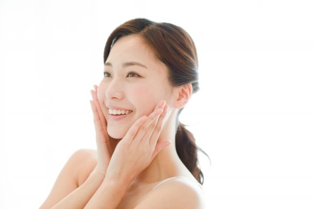 笑顔で頬を押さえる女性