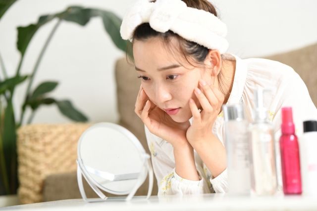 鏡で肌を確認する女性