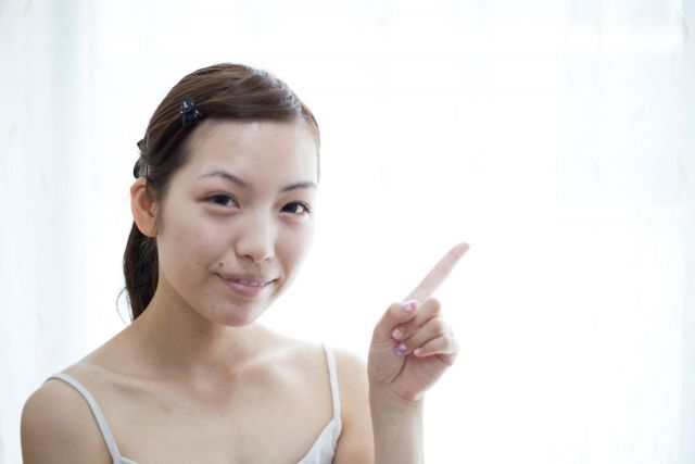 指を立てる女性