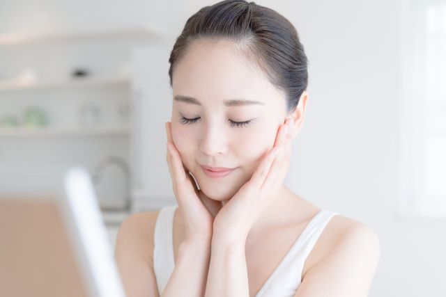 両手で頬を押さえる女性